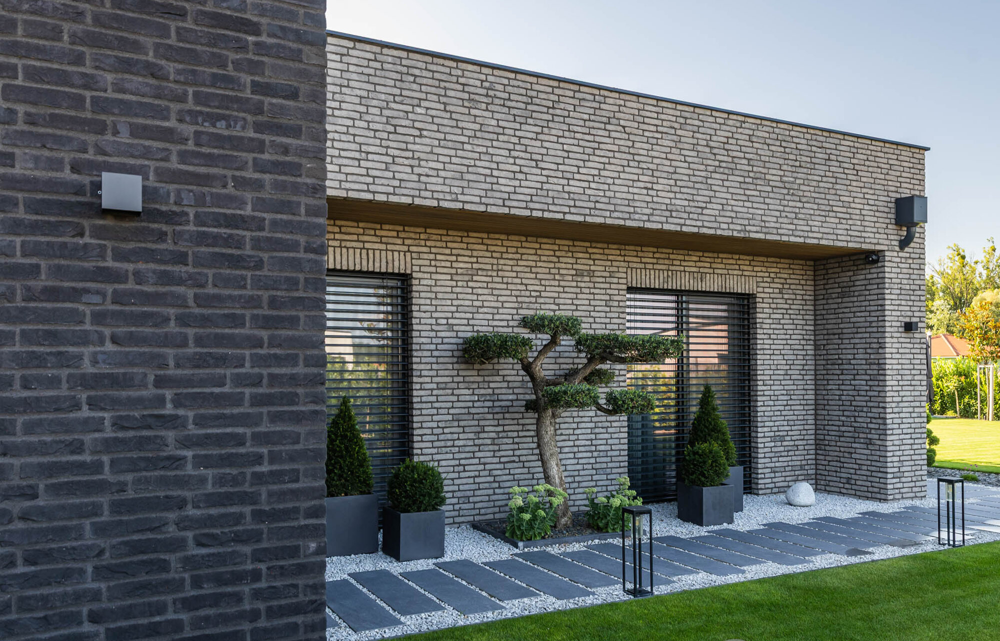 Kombinácia tehlových obkladov Akita a Zwart Super na fasáde a plote rodinného domu od Rustique.sk
